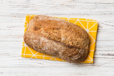 Taze ev yapımı tam buğday ekmeği. Peçetedeki ekmek kırsal arka planda, taze ekmek üst görünümü.