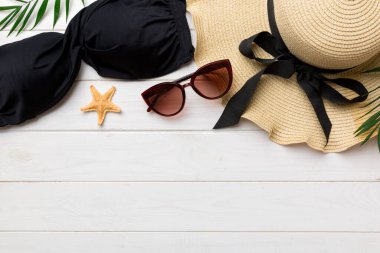 Woman swimwear and beach accessories flat lay top view on colored background Summer travel concept. bikini swimsuit, straw hat and seasheels. Copy space Top view.