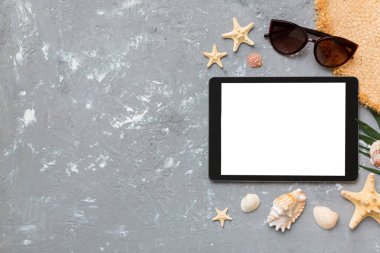 Renkli arka planda tablet ve plaj aksesuarlarıyla düz kompozisyon. Boş ekran ile tablet bilgisayarı kopyalama alanı ile maket.
