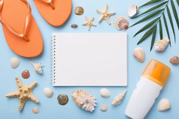 Blank writing book with summer beach accessories on background, copy space. Flat lay with copy space.