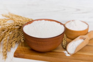 Tahta kasede buğday unu ve renkli arka planda buğday dikenleri. dünya buğday krizi.