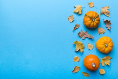 Sonbahar kompozisyonu. Masadaki kurumuş yapraklar ve diğer tasarım aksesuarlarından oluşan desen. Düz yatış, üst görünüm.