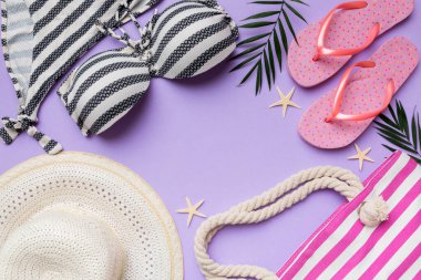 Kadın mayo ve plaj aksesuarları renkli arka plan yaz seyahati konseptine düz bir görünüm kazandırıyordu. Bikini mayo, hasır şapka ve deniz topuklu ayakkabı. Üst görünümü kopyala.