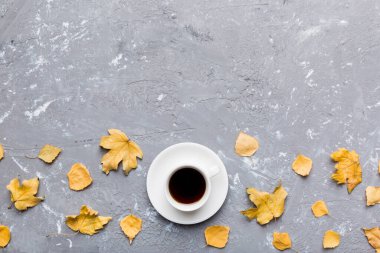 Renkli sonbahar kahve fincanı ve renkli yapraklarla bezenmiş düz bir kompozisyon. en üstteki görünüm.