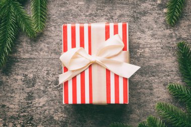 Noel kompozisyonu. Noel hediyesi ve çimento arka planında köknar dalları. Düz konum, üst görünüm, kopyalama alanı.