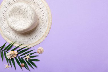 Summer holidays. Summer concept with straw hat and tropical leaf. Flat lay, top view, copy space.