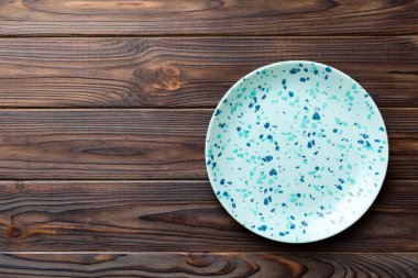 Ahşap zemindeki boş mavi tabağın üst görüntüsü. Tasarımın için boş boşluk.