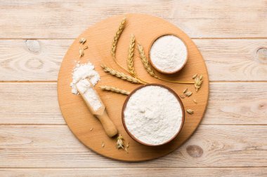 Tahta kasede buğday unu ve renkli arka planda buğday dikenleri. dünya buğday krizi.