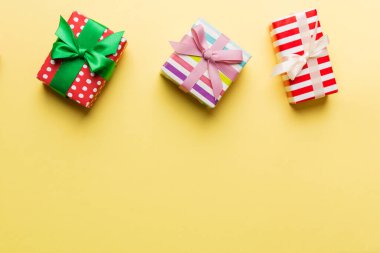 Renkli kağıda sarılı ve renkli arka planda konfetiyle süslenmiş hediye kutularıyla tatil dairesi yatıyordu. Noel, Doğum günü, Sevgililer Günü ve satış konsepti, üst manzara.