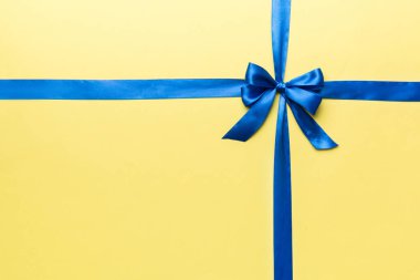 Mor kurdelenin üst görüntüsü yuvarlandı ve pembe fiyonk renkli arka planda izole edildi. Kopyalama alanı olan düz.