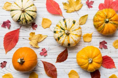 Sonbahar kompozisyonu. Masadaki kurumuş yapraklar ve diğer tasarım aksesuarlarından oluşan desen. Düz yatış, üst görünüm.