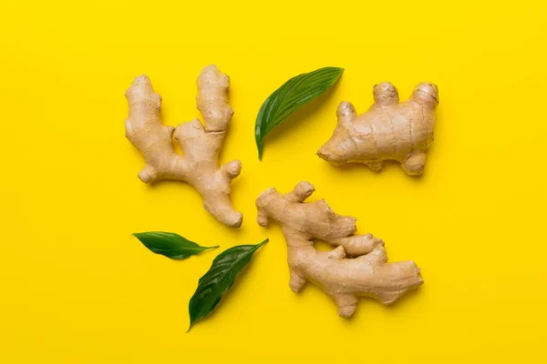 Finely dry Ginger powder in bowl with green leaves isolated on colored background. top view flat lay.