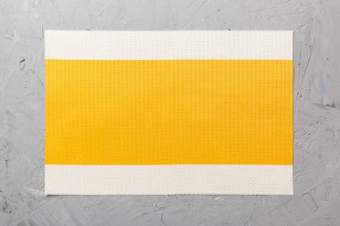 Çimento arka planındaki yemek için sarı masa örtüsünün üst görüntüsü. Tasarımın için boş boşluk.