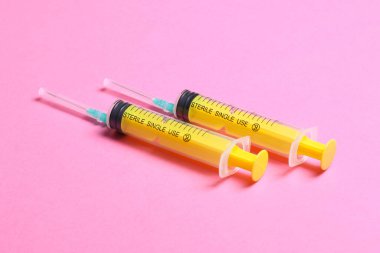 Renkli arkaplanda fotokopi alanı olan tıbbi enjeksiyon için üst sıradaki şırıngaların görüntüsü. Sağlık ve aşı kavramı.
