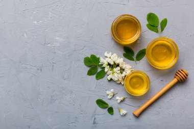 Akasya çiçekli ve yapraklı bal kavanozu. Taze bal üst görünüm düz yatıyordu.