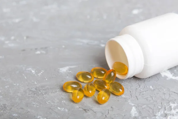 Omega-3 capsules lie in white bottle on a table background. Fish oil tablets top view. Biologically active additives. omega 6, omega 9, vitamin A, E, vitamin D, vitamin D3, evening primrose oil.