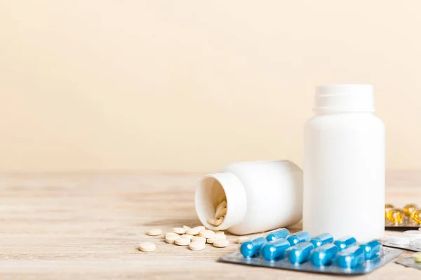 Medicine for treatment HIV infection. Pills and capsules and battle on the table. Different colorful tablets at colored background with copy space.