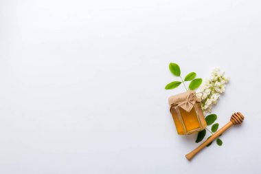 Akasya çiçekli ve yapraklı bal kavanozu. Taze bal üst görünüm düz yatıyordu.