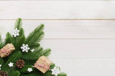 Noel süslemeleri, köknar ağacı dalları ve hediye kutusundaki karanlık masa. Kopyalama alanı olan üst görünüm çerçevesi.