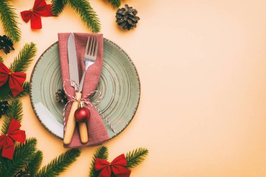 Noel süsleri, tabaklar, inekler, çatallar ve kaşıklarla Noel sofrası. Noel tatili geçmişi. Kopyalama alanı olan üst görünüm.