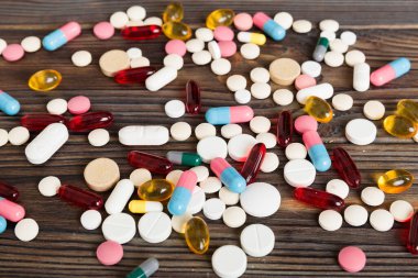 Çeşitli ilaç ve haplardan oluşan bir koleksiyon. Masa arkasında çeşitli ilaç hapları, haplar ve kapsüller var. Çeşitli ilaç tabletleri yığını. Sağlık hizmetleri.