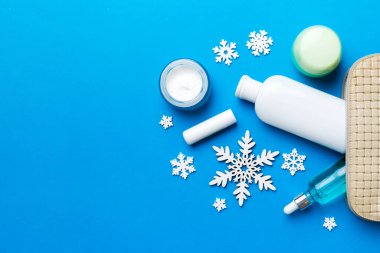 Noel dairesi renkli arka planda makyaj malzemeleriyle kozmetik poşetlerde yatıyordu. Üst Görünüm Yeni Yıl Güzellik Konsepti.