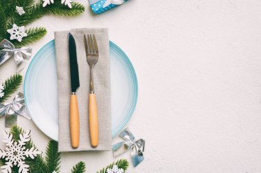 Noel süsleri, tabaklar, inekler, çatallar ve kaşıklarla Noel sofrası. Noel tatili geçmişi. Kopyalama alanı olan üst görünüm.