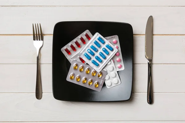 Many different weight loss pills and supplements as food on round plate. Pills served as a healthy meal. Drugs, pharmacy, medicine or medical healthycare concept.