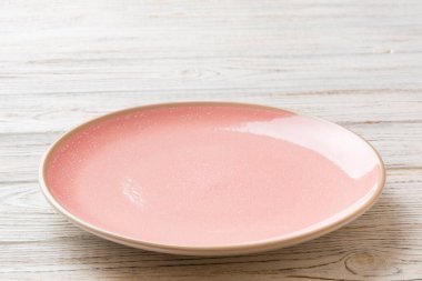 Ahşap arka planda boş pembe plaka manzarası. Tasarımın için boş boşluk.