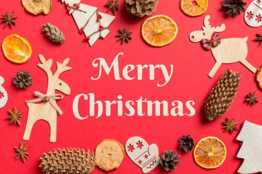 Mutlu Noeller mesajı. Noel oyuncakları, ren geyikleri ve yılbaşı ağaçlarıyla süslenmiş kırmızı arka plan manzarası. Kopya alanı ile tatil kavramı.