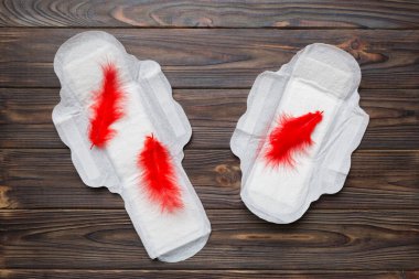 Kadın hijyen ürünleri ya da arka planda kırmızı tüy olan hijyenik ped. Pastel renk. - Yakın çekim. Mesaj için boş bir yer. Kadın günlük hijyeni..