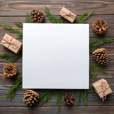 Noel kompozisyonu düzdü. Kare kağıt boş, çam ağacı dalları, renkli arka planda noel süslemeleri. Üst görünüm, metin için boşluk kopyala.