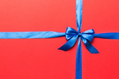 Mor kurdelenin üst görüntüsü yuvarlandı ve pembe fiyonk renkli arka planda izole edildi. Kopyalama alanı olan düz.