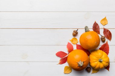 Sonbahar kompozisyonu. Masadaki kurumuş yapraklar ve diğer tasarım aksesuarlarından oluşan desen. Düz yatış, üst görünüm.