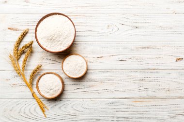 Tahta kasede buğday unu ve renkli arka planda buğday dikenleri. dünya buğday krizi.