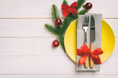 Noel süsleri, tabaklar, inekler, çatallar ve kaşıklarla Noel sofrası. Noel tatili geçmişi. Kopyalama alanı olan üst görünüm.