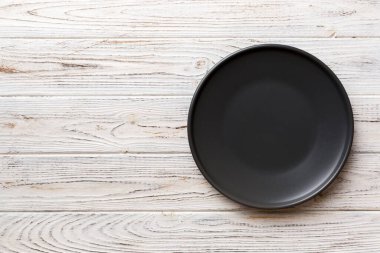 Ahşap arka plandaki siyah plakanın üst görüntüsü. Tasarımın için boş boşluk.