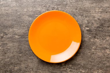 Çimento arka planındaki boş turuncu plakanın üst görüntüsü. Tasarımın için boş boşluk.