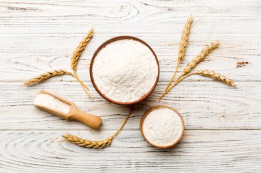 Tahta kasede buğday unu ve renkli arka planda buğday dikenleri. dünya buğday krizi.