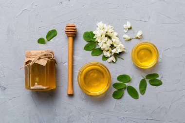 Akasya çiçekli ve yapraklı bal kavanozu. Taze bal üst görünüm düz yatıyordu.