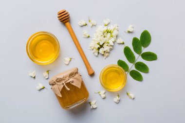 Akasya çiçekli ve yapraklı bal kavanozu. Taze bal üst görünüm düz yatıyordu.