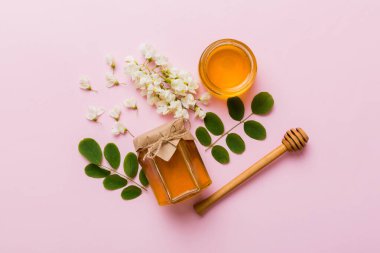 Akasya çiçekli ve yapraklı bal kavanozu. Taze bal üst görünüm düz yatıyordu.