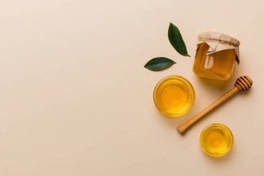 Bal kavanozu, beyaz arka plan manzaralı ve fotokopi alanı olan ahşap bal kaplama. Lezzetli bal şişesi.