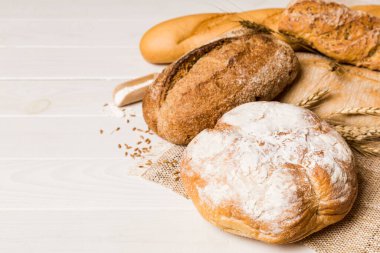 Ev yapımı doğal ekmek. Arkaplan olarak taze ekmeğin farklı türleri, kopya alanı ile perspektif.