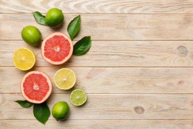 Meyve arkaplanı. Renkli masada renkli taze meyveler. Portakal, limon, greyfurt. Sağlıklı yazı kavramı için. Düz konum, üst görünüm, kopyalama alanı.