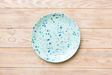 Ahşap zemindeki boş mavi tabağın üst görüntüsü. Tasarımın için boş boşluk.