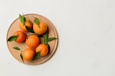 Taze kesilmiş mandalinalar ve renkli arka planda yuvarlak tabaklar. Yemek ve içecek malzemeleri hazırlanıyor. Sağlıklı beslenme teması üst görünüm kopyalama alanı.