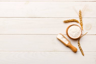 Tahta kasede buğday unu ve renkli arka planda buğday dikenleri. dünya buğday krizi.