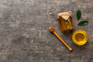 Bal kavanozu, beyaz arka plan manzaralı ve fotokopi alanı olan ahşap bal kaplama. Lezzetli bal şişesi.