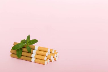 Renkli arka planda mentollü sigara ve taze nane yaprakları üst üste yığılmış pek çok sigara düz yatıyordu..